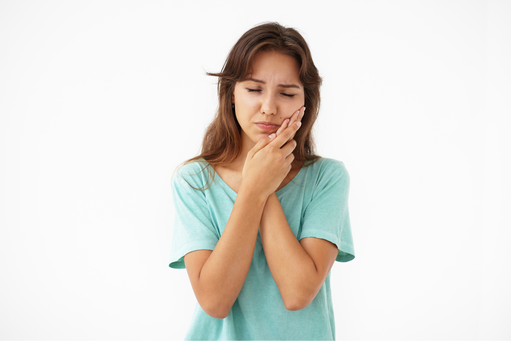 Mujer joven con dolor de boca por caries o gingivitis