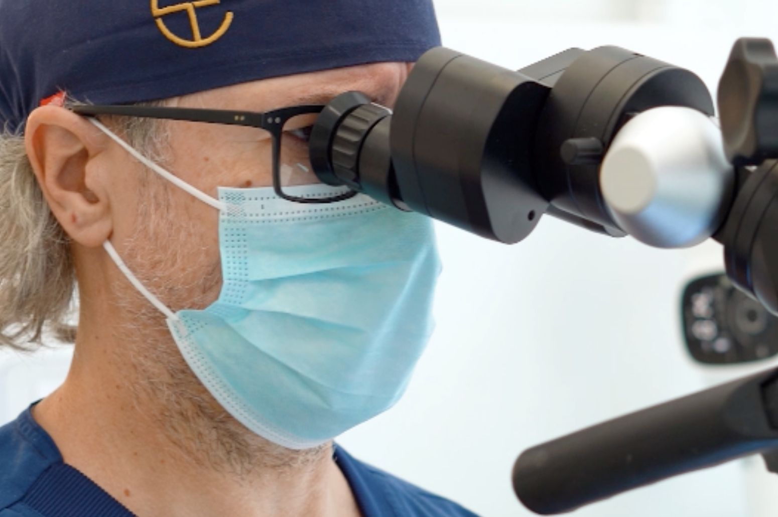 Dentista utilizando un microscopio dental para realizar un tratamiento de precisión en Carrero & Tezza Clínica Dental.