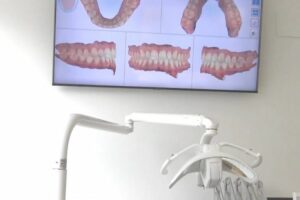 Dentista mostrando en pantalla el diseño digital de sonrisa de un paciente en Carrero & Tezza
