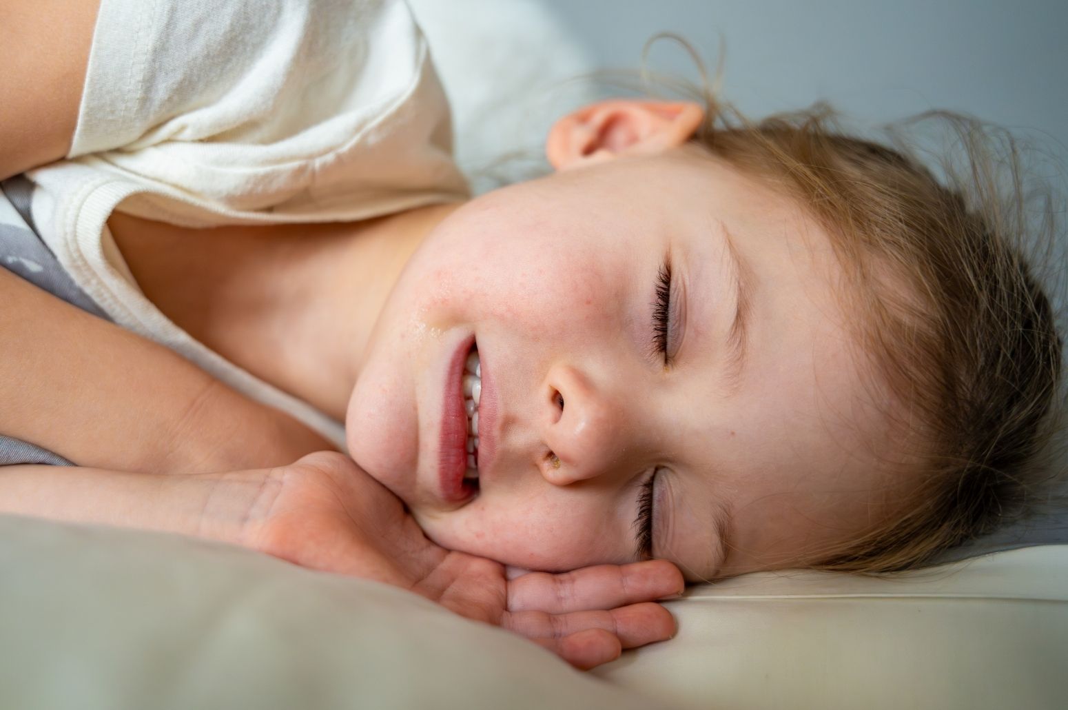 Niña durmiendo mientras aprieta los dientes, síntoma común del bruxismo tratado con el tratamiento del bruxismo en Carrero & Tezza.