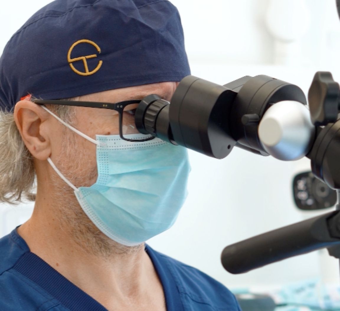 Dentista utilizando un microscopio dental en Carrero & Tezza en León.le